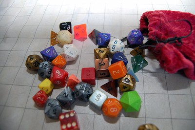 A tabletop grid with a dice bag and dice spilled across the table.