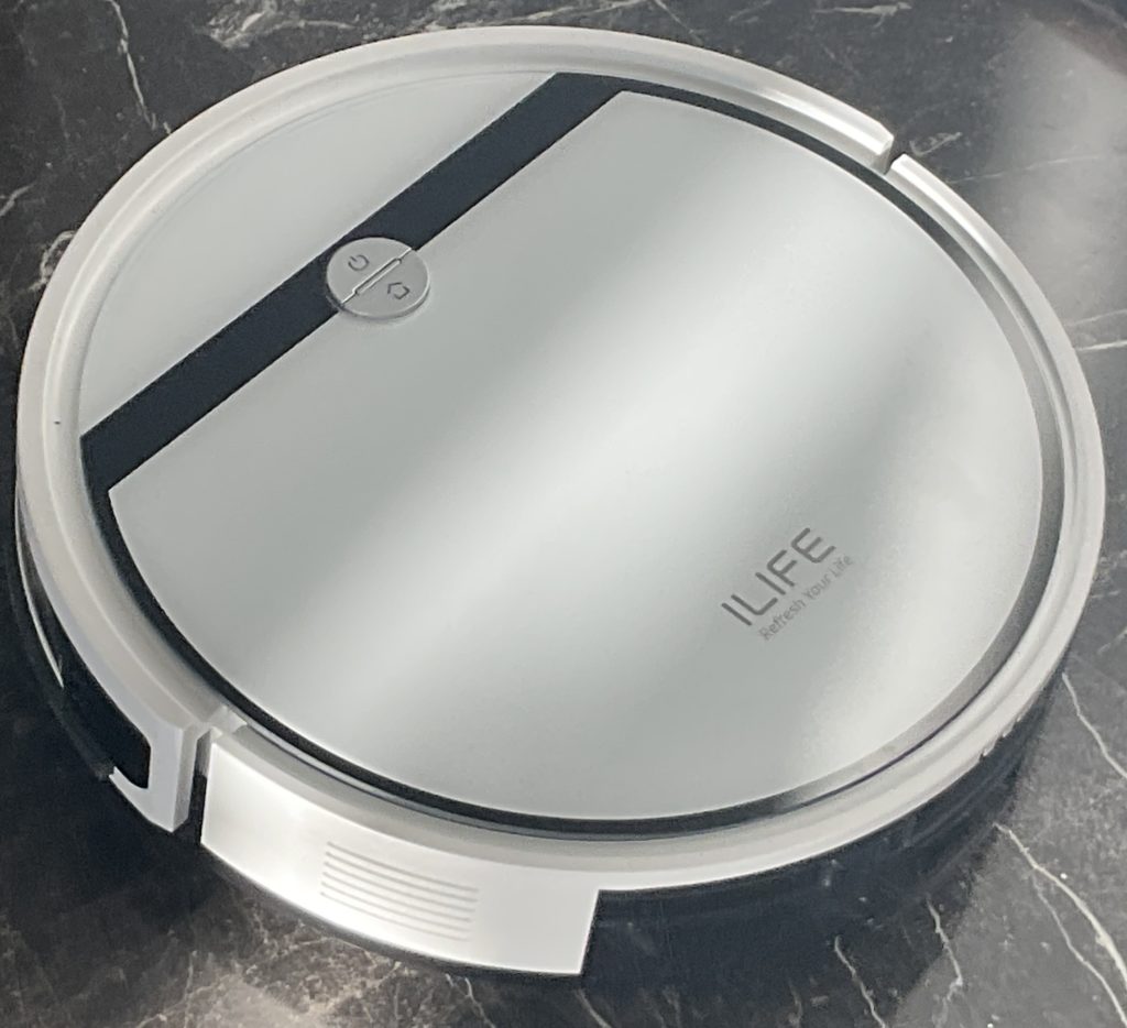 A black and white photo of an iLife brand cleaning robot